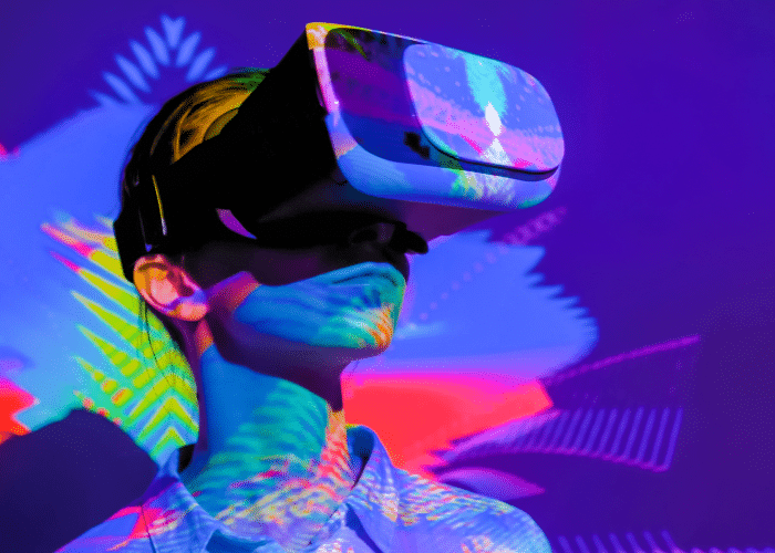 Person wearing a virtual reality headset with colorful digital projections in the background.