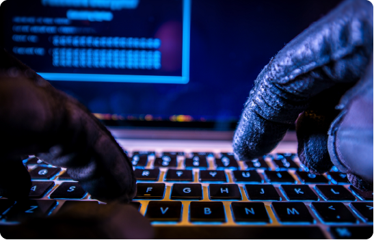 Gloved hands typing on a laptop keyboard, highlighting cybersecurity threats in the food delivery industry.